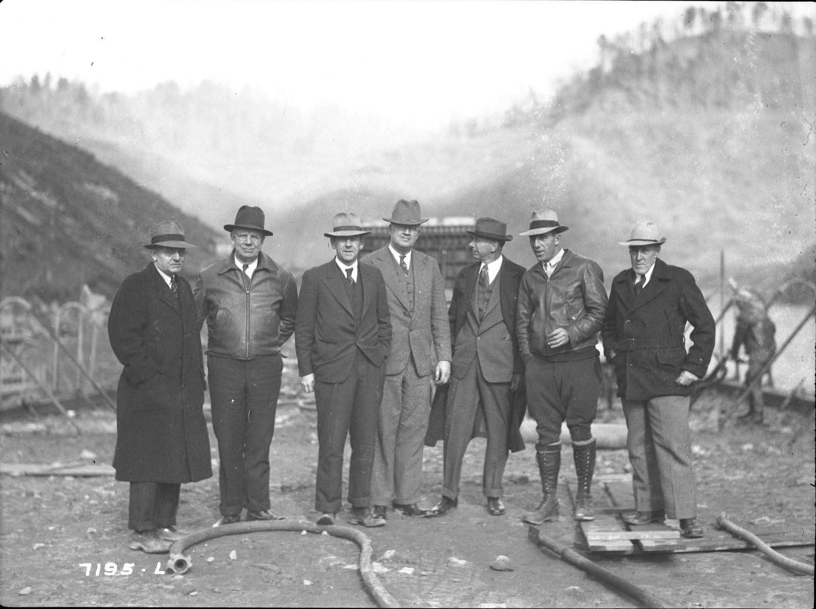 Consulting engineers in hats and coats at the dam site