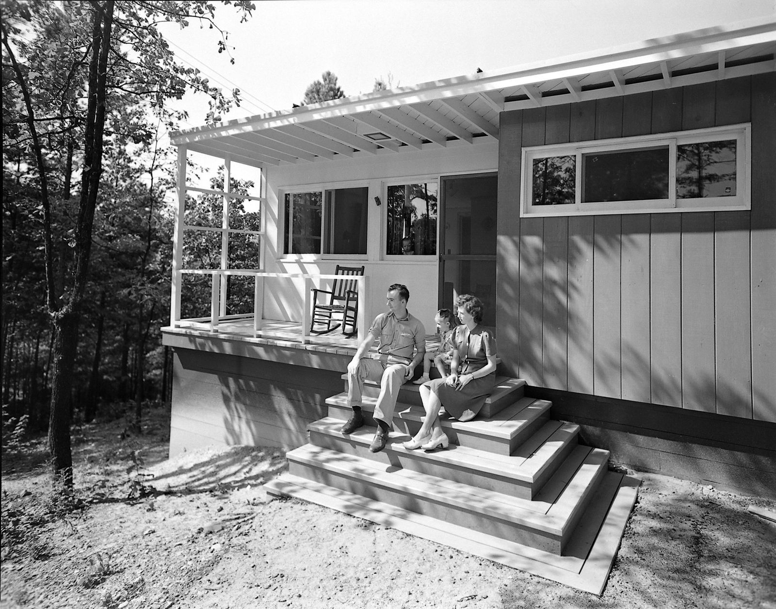 A family on the front steps of their new house in Smith Creek Village